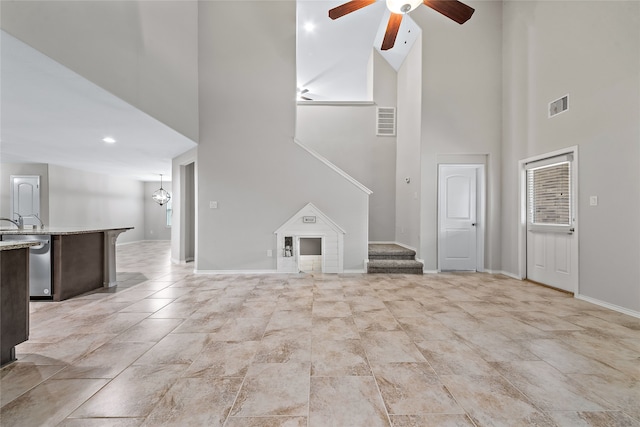 unfurnished living room featuring ceiling fan and high vaulted ceiling