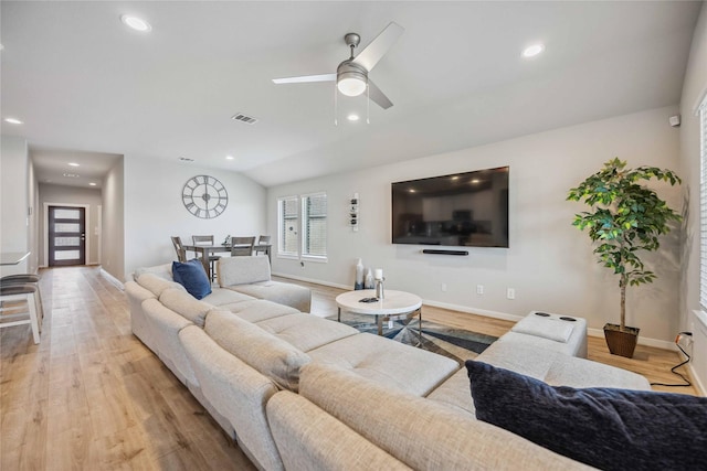 living room featuring light hardwood / wood-style floors, vaulted ceiling, and ceiling fan