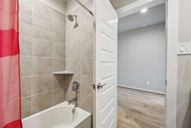 bathroom with hardwood / wood-style floors and shower / bathtub combination with curtain