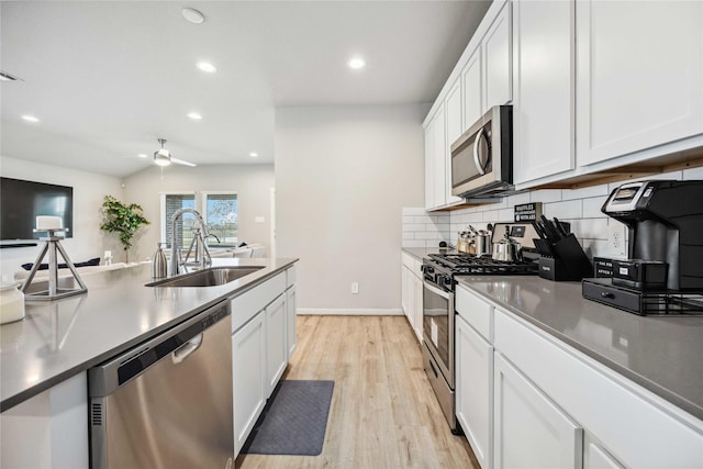 kitchen featuring white cabinets, backsplash, sink, and stainless steel appliances