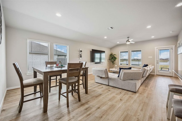 dining space with ceiling fan, vaulted ceiling, and light hardwood / wood-style flooring