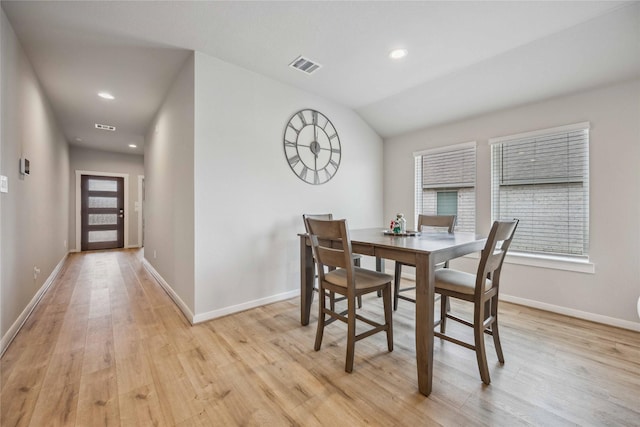 dining room featuring light hardwood / wood-style floors and lofted ceiling