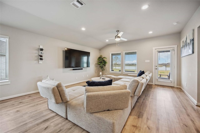 living room featuring ceiling fan, lofted ceiling, and light hardwood / wood-style flooring