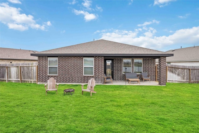 rear view of house featuring a fire pit, a patio area, and a lawn