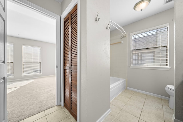 bathroom with tile patterned floors, shower / bathing tub combination, and toilet