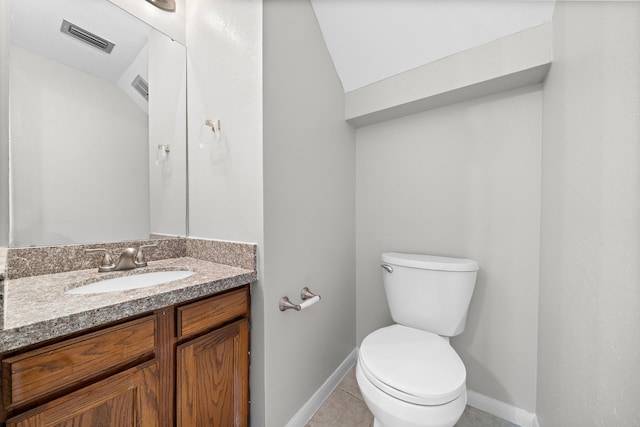 bathroom with tile patterned floors, vanity, toilet, and lofted ceiling