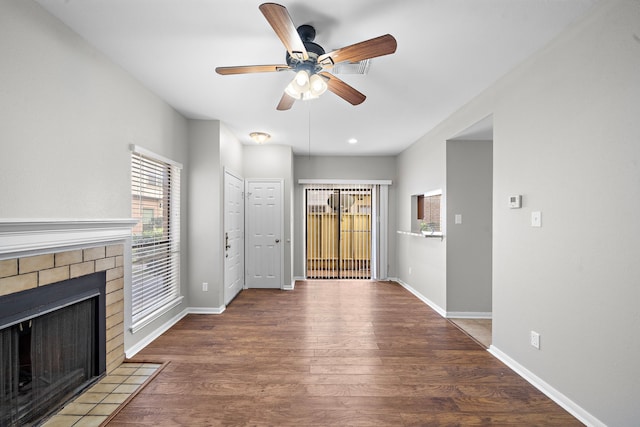 unfurnished living room with hardwood / wood-style floors, ceiling fan, and a fireplace