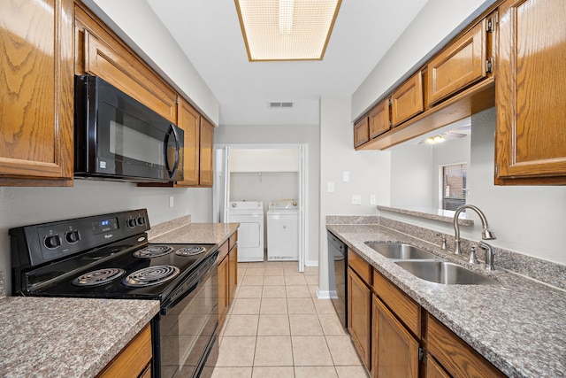 kitchen featuring black appliances, sink, ceiling fan, washing machine and dryer, and light tile patterned flooring