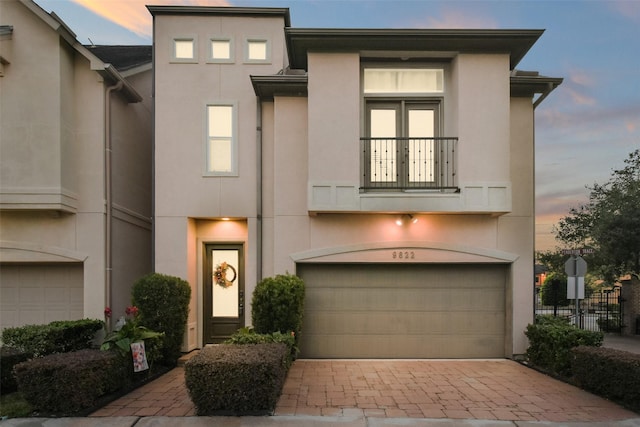 view of front of home featuring a garage and a balcony