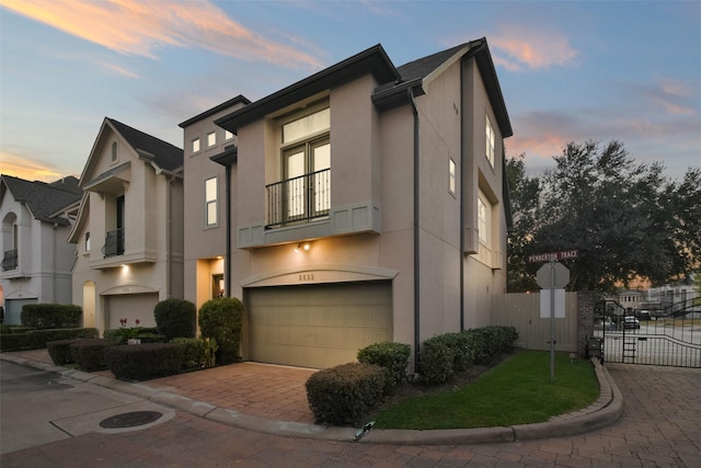 view of front of home with a garage and a balcony