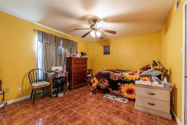 bedroom with ceiling fan and dark tile patterned floors