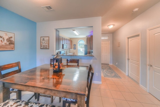 dining area featuring light tile patterned flooring