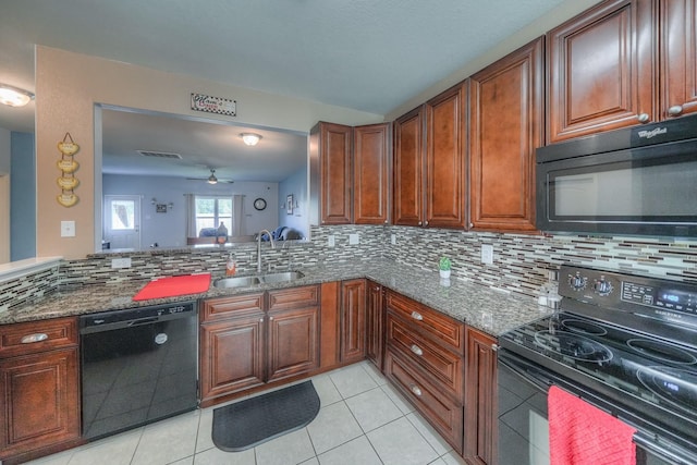 kitchen with tasteful backsplash, dark stone countertops, sink, and black appliances