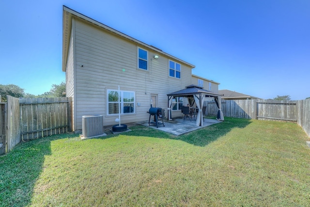 rear view of house featuring a gazebo, central AC unit, and a lawn