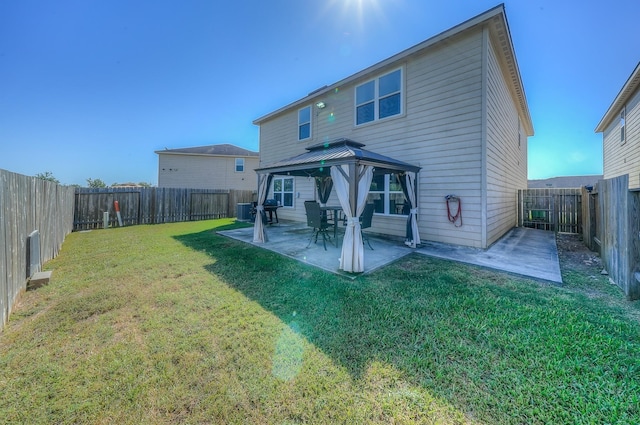 rear view of property with a gazebo, a patio area, a yard, and central air condition unit