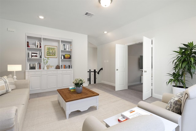 carpeted living room with built in features and vaulted ceiling