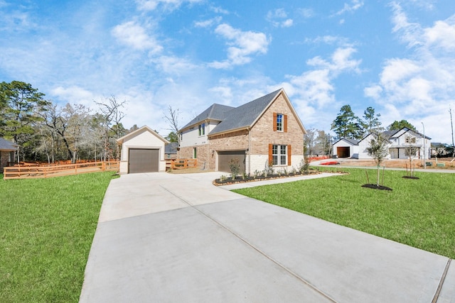 view of front of property with a garage, concrete driveway, an outbuilding, a front yard, and brick siding