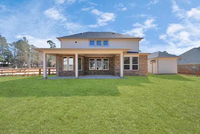 rear view of property featuring fence private yard, brick siding, a lawn, and a patio