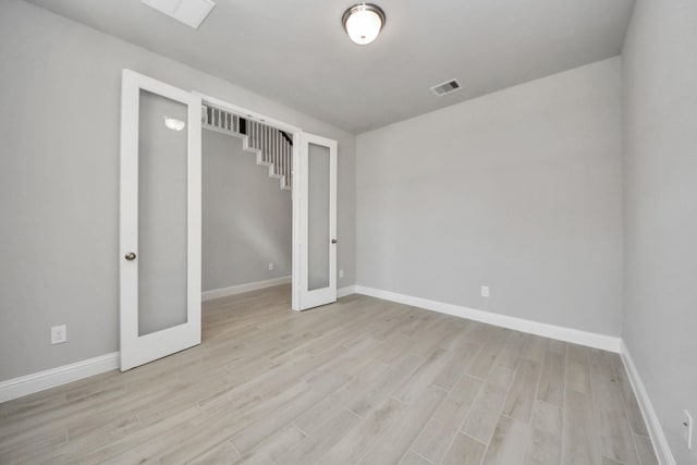 spare room with baseboards, visible vents, wood finished floors, and french doors