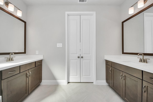 full bathroom with visible vents, two vanities, and a sink