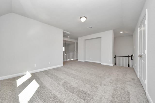 unfurnished room with carpet floors, recessed lighting, attic access, vaulted ceiling, and baseboards