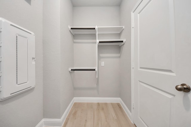 walk in closet with light wood finished floors