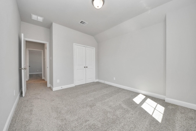 unfurnished bedroom with a closet, visible vents, and carpet flooring