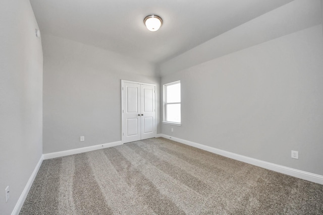 empty room with carpet and baseboards