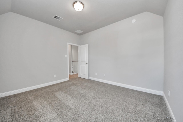 unfurnished room featuring carpet, visible vents, vaulted ceiling, and baseboards