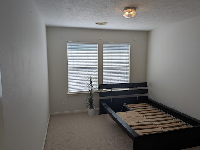 bedroom with carpet flooring and a textured ceiling