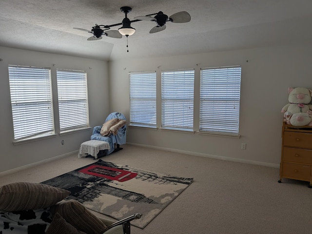 interior space featuring ceiling fan, carpet floors, and lofted ceiling