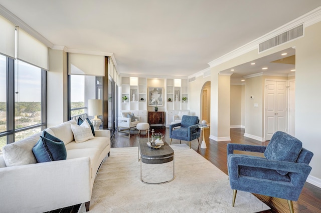 living room with hardwood / wood-style flooring, built in features, and crown molding