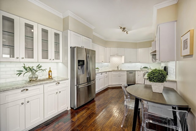 kitchen with light stone counters, sink, white cabinets, and stainless steel appliances