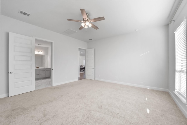 unfurnished bedroom featuring ensuite bathroom, ceiling fan, and light carpet