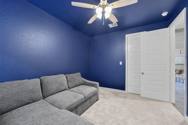 carpeted living room with ceiling fan