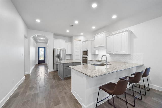 kitchen featuring sink, stainless steel appliances, white cabinetry, and a kitchen island