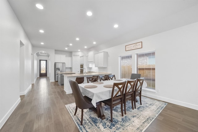 dining space with sink, dark hardwood / wood-style floors, and plenty of natural light