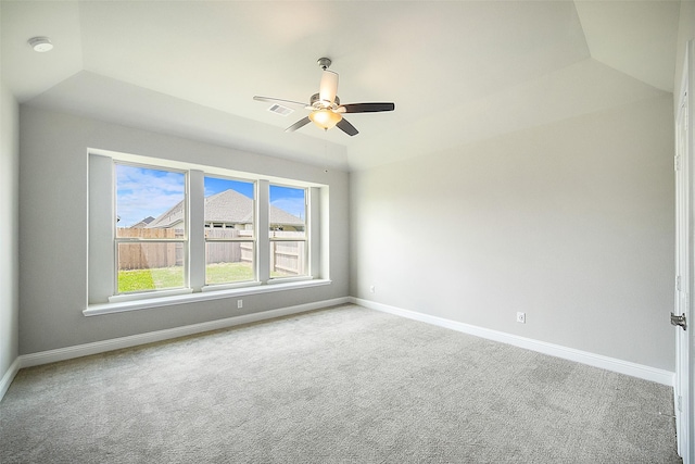 empty room featuring lofted ceiling, ceiling fan, baseboards, and carpet flooring