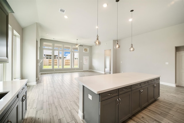 kitchen featuring a center island, ceiling fan, light hardwood / wood-style floors, and decorative light fixtures