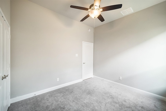 carpeted empty room with a high ceiling and ceiling fan