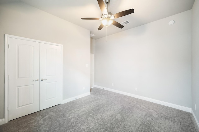 unfurnished bedroom featuring ceiling fan, a closet, and carpet