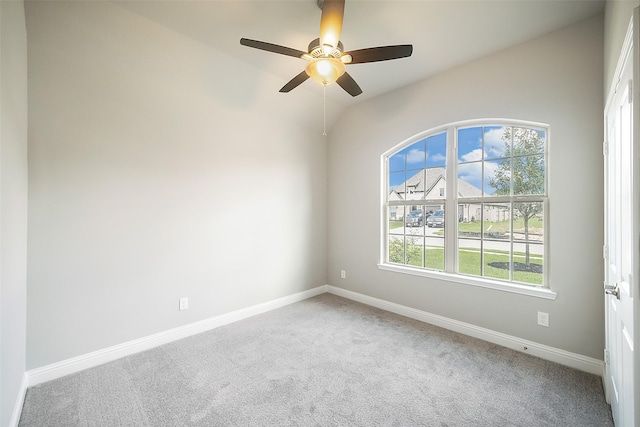 unfurnished room featuring carpet floors, lofted ceiling, baseboards, and a ceiling fan