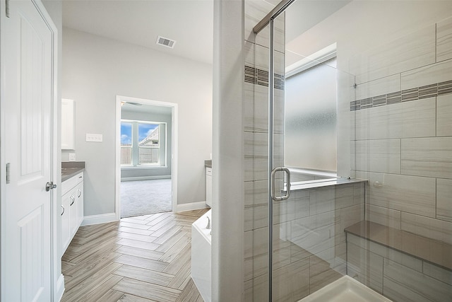 bathroom with a stall shower, visible vents, vanity, and baseboards