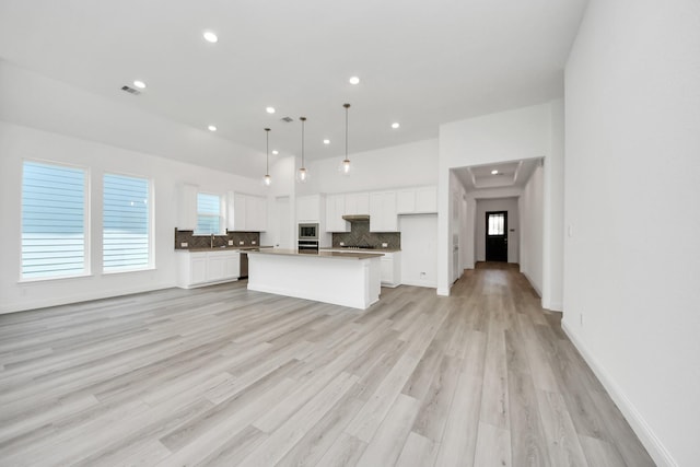 17733 Gold Saddle Ln, Magnolia, TX 77354 - kitchen with backsplash, open floor plan, a center island, white cabinets, and appliances with stainless steel finishes