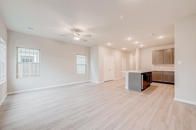 kitchen featuring sink, a center island with sink, light wood-type flooring, dishwasher, and ceiling fan