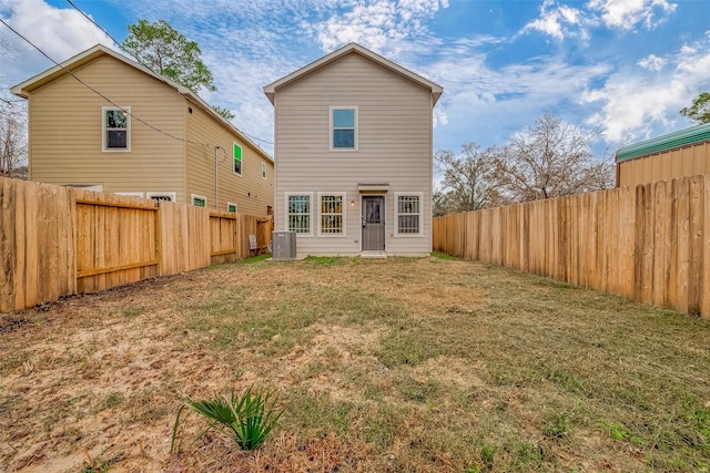 back of house featuring central AC and a lawn