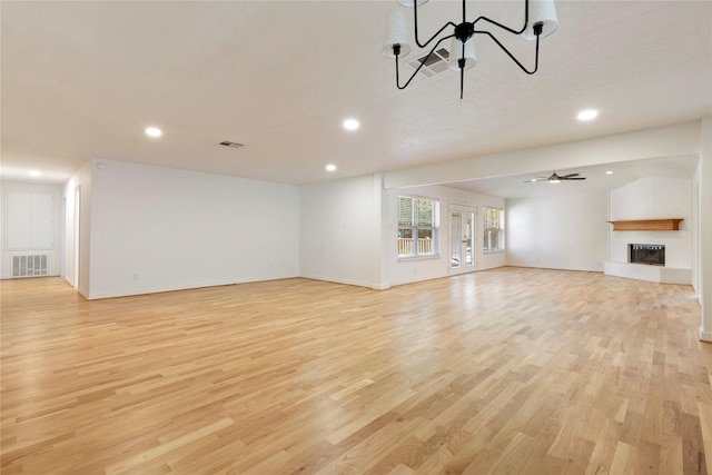 unfurnished living room with a fireplace, light hardwood / wood-style floors, and ceiling fan