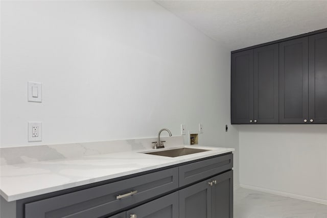 washroom featuring cabinets, washer hookup, a textured ceiling, and sink