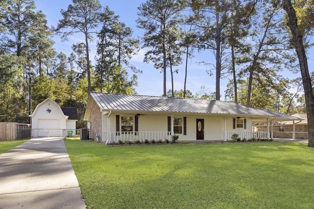 ranch-style home with covered porch, an outbuilding, a garage, and a front yard