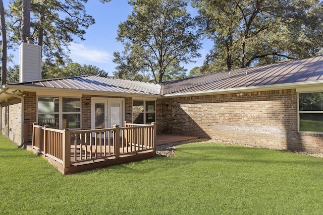 back of house with a lawn and a deck